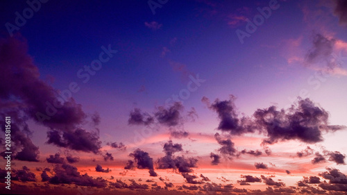 Bild auf Leinwand Stunning twilight sky with vibrant orange gradient and scattered dark clouds at