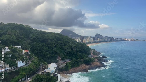 A panoramic coastal city view on the Copacabana beach with favelas on the foreground