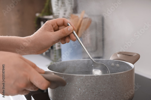 Female hands boiling water ...