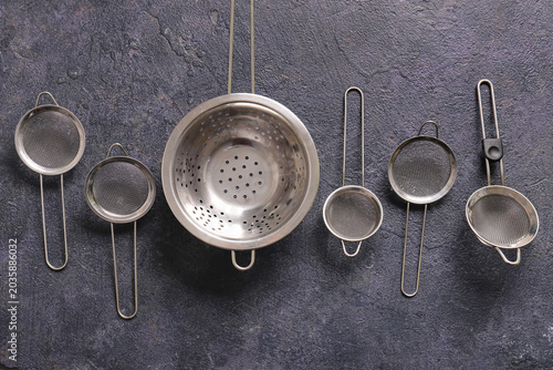 Quadro su tela Different sieves with colander on grey grunge background