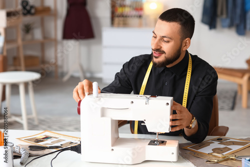 Male tailor using sewing ma...