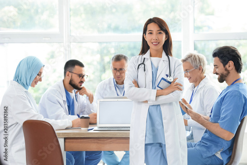 Female Asian doctor and her colleagues in clinic