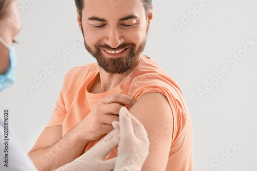Young man receiving vaccine in clinic, closeup