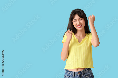 Smiling young woman on blue...
