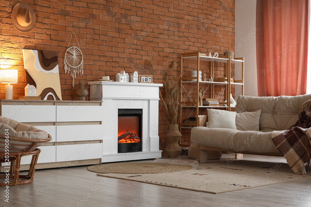 Fototapeta premium Interior of stylish modern living room with fireplace, sofa and commode near brick wall
