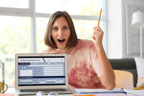 Teenage girl filling out college application form at home