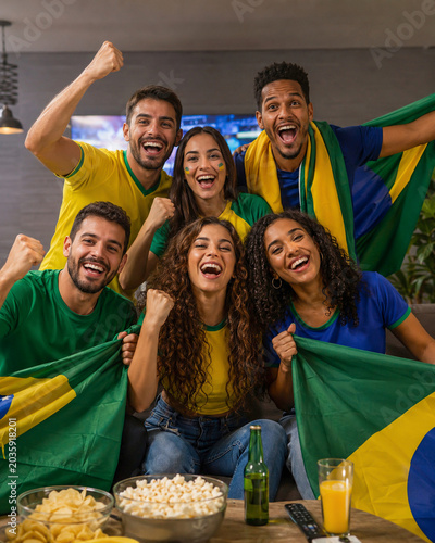 Torcedores brasileiros comemorando jogo de futebol em casa