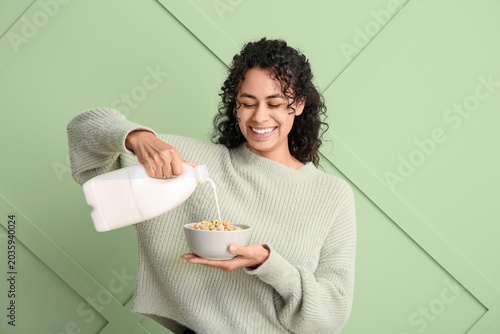 Happy young woman pouring m...