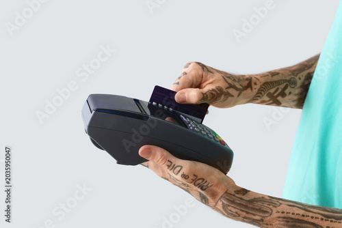 Tattooed young man paying w...