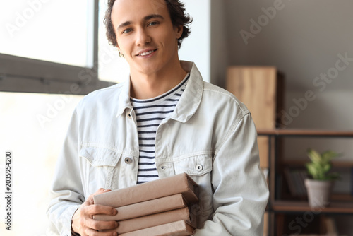 Young man with books in library