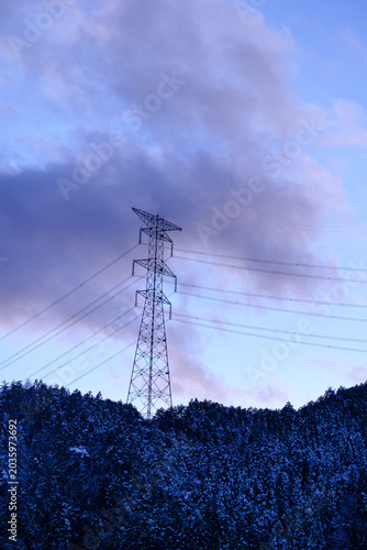Vertical view of high voltage electricity pylon silhouette under golden sunset. Inspiring backdrop for psychological resilience under pressure, mental wellness and public utility power