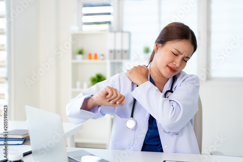 Canvas Print Stress, young  doctor with body pain in a medical office suffering from body ache or overworked