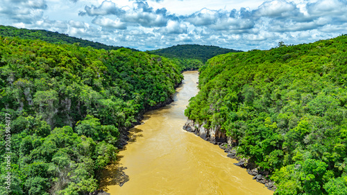 Photos The Guayabero River flows through vibrant green hills under a partly cloudy sky in Colombia's Guaviare region