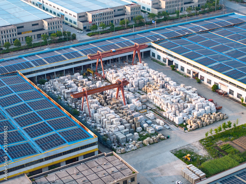 Fotografie Aerial view of industrial factory rooftops covered with solar panels and storage
