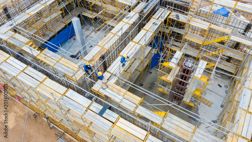 Cuadro en lienzo Aerial View of Construction Site: An expansive construction site, bustling with activity, features complex scaffolding, concrete structures