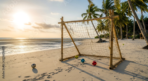 Beach Football Goal with Balls on Sandy Shore at Sunset with Palm Trees