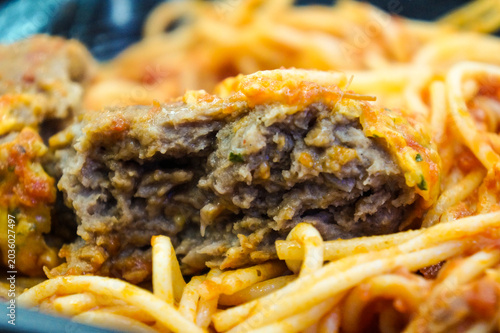 Fotografija A ready-to-eat instant Italian-style pasta container filled with spaghetti noodles covered in sweet tomato meat sauce and melted cheese
