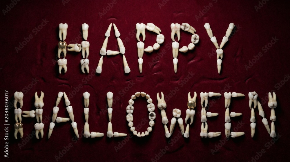 Fototapeta premium Creepy White Teeth Forming Happy Halloween Message on Dark Red Fabric Background