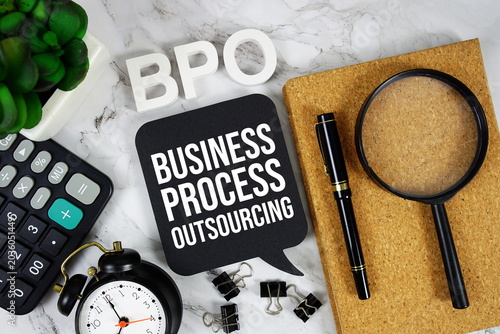 BPO - Business Process Outsourcing acronym with calculator, alarm clock and magnifying glass, business concept background