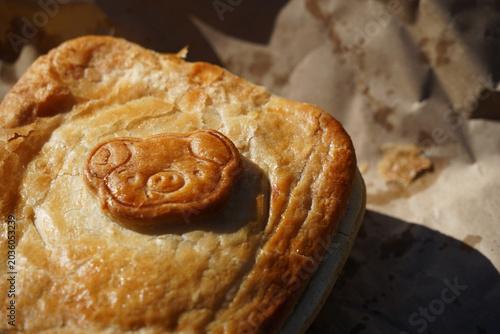 A fresh hot pork pie with a cute pig pastry stamp on the top