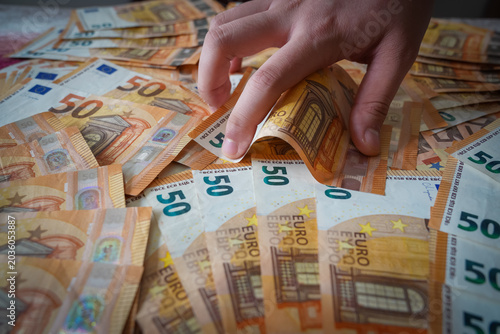 Bild auf Leinwand Close-up of a hand grabbing 50 euro banknotes, representing taxes or greed