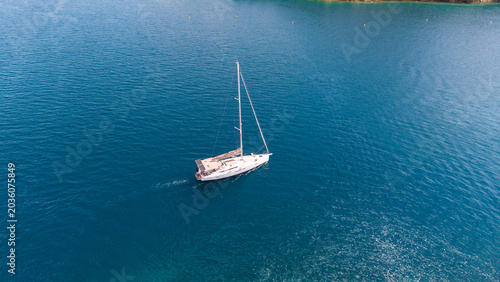 Fotografie Single white sailboat glides across a vast expanse of deep blue ocean water