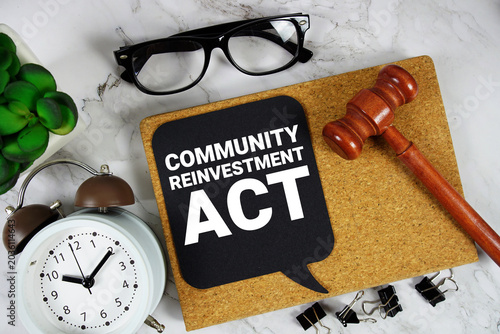 Fényképezés CRA Community Reinvestment Act text on speech bubble with alarm clock and wooden