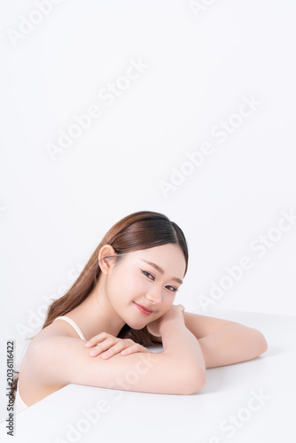 Beautiful young asian woman resting chin on hands with healthy skin on white background, for beauty, makeup and cosmetic concept.	