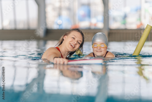 Foto Teacher giving swimming lesson to girl with down syndrome