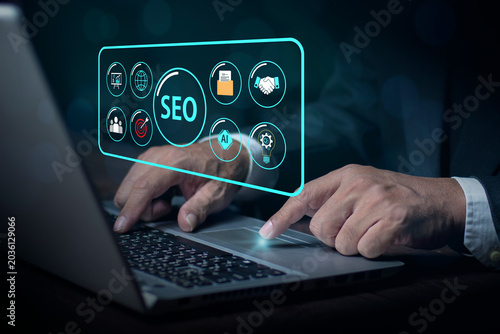 Man using laptop with digital search SEO (Search Engine Optimization) on a screen symbolizing the action of searching the web or internet browsing with a focus on technology. Online search concept.