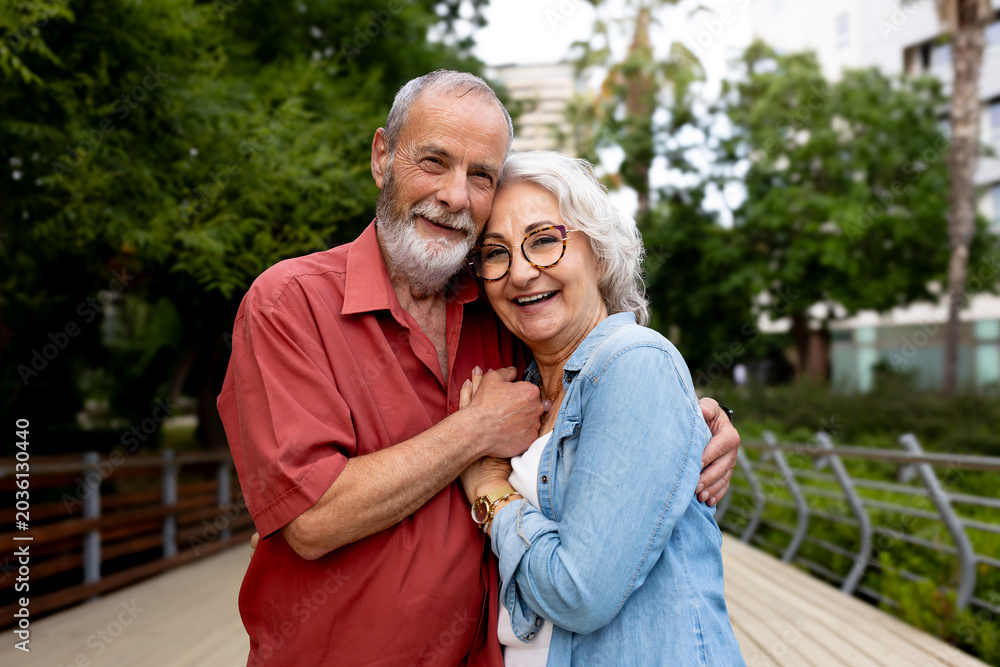 Fototapeta premium Happy senior couple embracing outdoors enjoying retirement life
