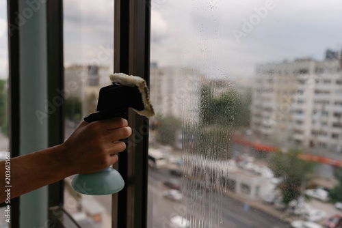 фотографія Close-up cropped shot of unrecognizable housekeeper spraying cleaning solution o