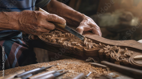 Closeup of a craftsman carving wood with hand tools.