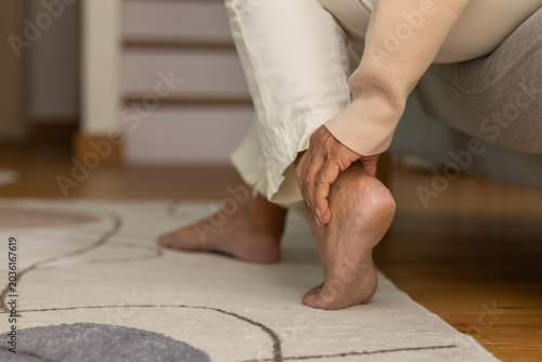 Bild auf Leinwand Person holding painful heel suffering from plantar fasciitis expressing discomfo
