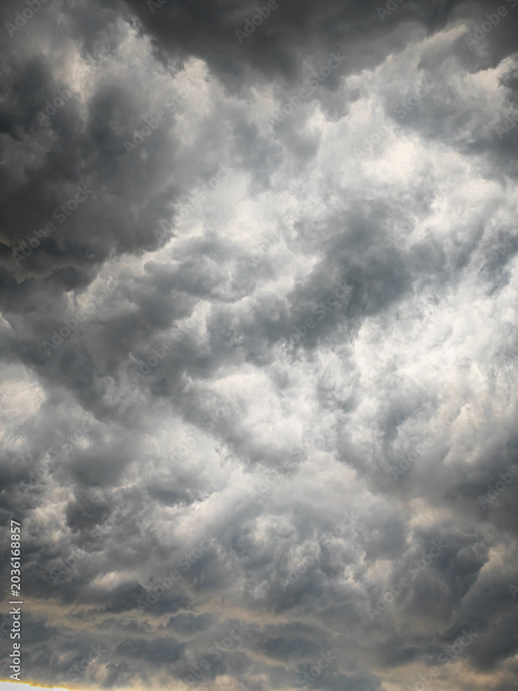 Fototapeta premium Storm clouds, A dramatic, high-contrast shot of black clouds that captures the turbulent and intense texture of a large storm front forming in a dark, gloomy sky.