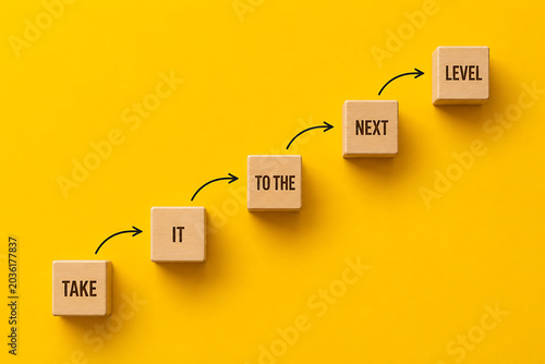 Motivational business growth staircase with take it to the next level message representing career advancement and success achievement