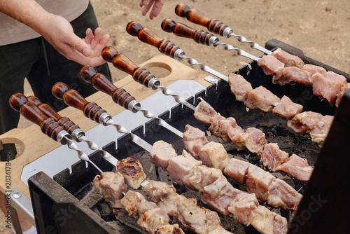 Photos Man grilling shish kebab shashlik on the barbecue skewers