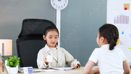 Photos Young Asian Girl in White Blazer Roleplaying as Businesswoman at Office Desk