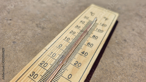 Obraz na płótnie a wooden thermometer lying on rough concrete under bright sun representing abnor
