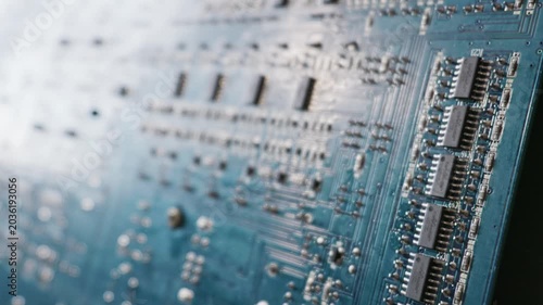 Detailed blue printed circuit board features aligned microchips and intricate conductive traces. Concept of modern computing hardware, electronic engineering, and digital processing.