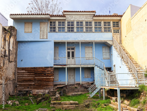 Historic Plaka house in Athens, showing layered facades, exterior stairs, and a secluded urban courtyard.