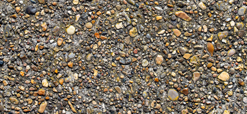 Fotografie Exposed aggregate concrete pavement surface with small colorful river pebbles te