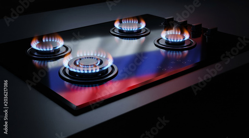 Modern black glass gas cooktop with four lit blue flame burners
