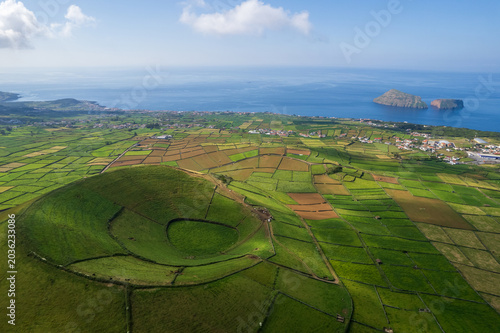 Aerial view of Terceira islans in Azores, Portugal. Volcanic landscape.  Drone shot of ancient Pico Dona Joana volcano and  cabras islet. Green fields in rural environment.