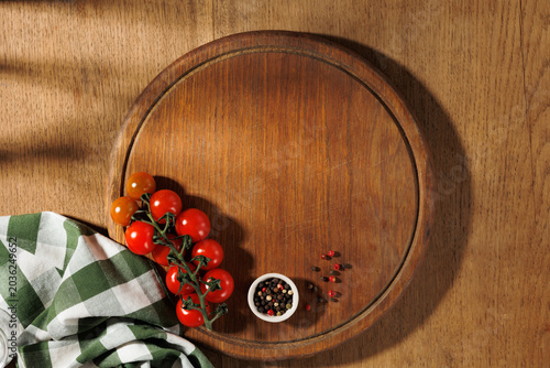Old round wooden cutting board and spices. Food background, top view copy space