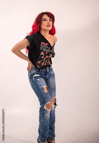 Woman posing in ripped jeans and red hair