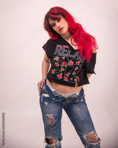 Woman with red hair posing in ripped jeans