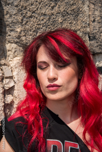 Young woman with vibrant red hair eyes closed