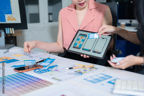 Fotografi UX developer and ui designer brainstorming about mobile app interface wireframe design with customer breif and color code at office