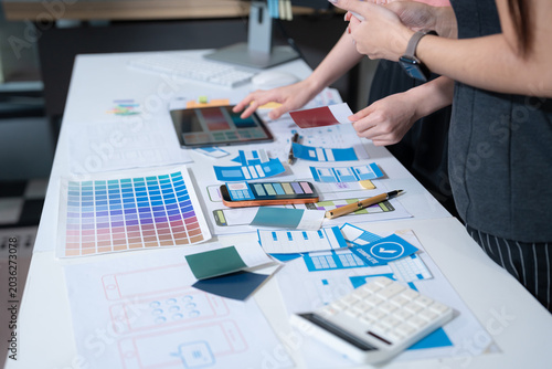 Fotografija UX developer and ui designer brainstorming about mobile app interface wireframe design with customer breif and color code at office